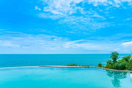 Beautiful outdoor infinity swimming pool in hotel resort with sea ocean view and white cloud blue sky for holiday vacation and travelの写真素材