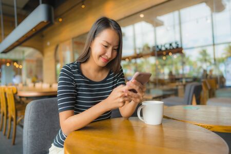 Portrait beautiful young asian women in coffee shop cafe and restaurant using mobile phoneの写真素材