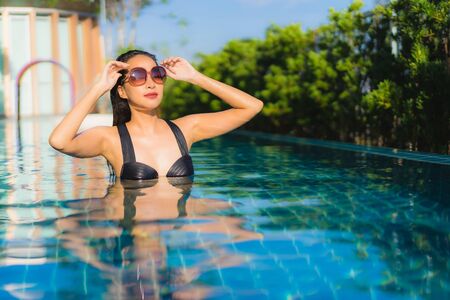Portrait beautiful young asian women happy smile relax outdoor swimming pool in resort hotel for vacation travelの写真素材