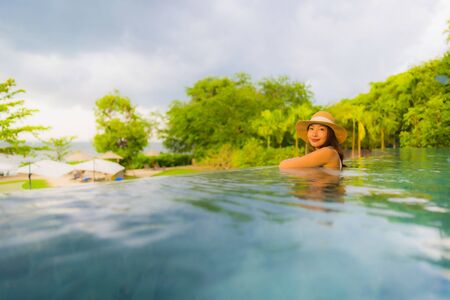 Portrait beautiful young asian women happy smile relax around outdoor swimming pool in hotel resort