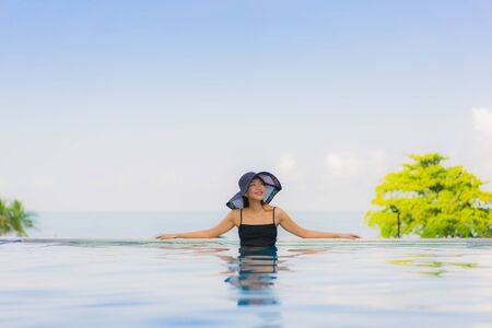 Portrait beautiful young asian women happy smile relax outdoor swimming pool in hotel resort in vacationの写真素材