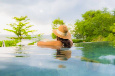 Portrait beautiful young asian women happy smile relax around outdoor swimming pool in hotel resortの写真素材
