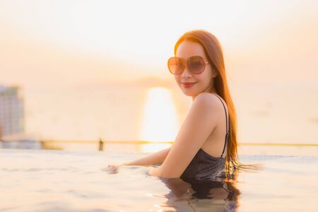Portrait beautiful young asian women happy smile relax outdoor swimming pool in hotel resort in...