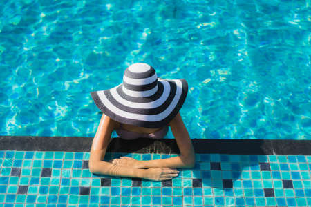 Beautiful portrait asian woman relax happy smile around outdoor swimming pool in holiday vacationの写真素材