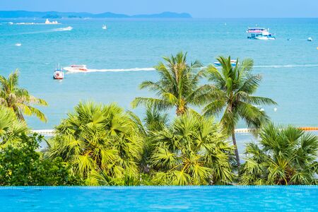 Beautiful outdoor swimming pool with ocean sea view and coconut palm tree for holiday vacation conceptの写真素材