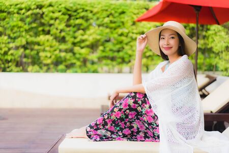 Portrait beautiful young asian women happy smile relax around swimming pool near sea beach ocean in hotel resortの写真素材
