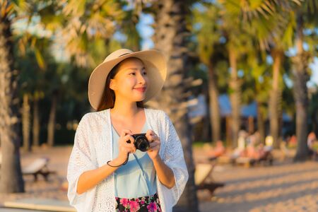 Portrait beautiful young asian women happy smile relax around beach sea ocean at sunset or sunrise time for travel vacationの写真素材