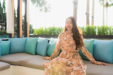 Portrait beautiful young asian women happy smile sit on sofa around outdoor viewの写真素材