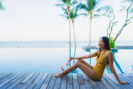 Portrait beautiful young asian women happy smile relax around outdoor swimming pool in hotel resort for travel vacationの写真素材