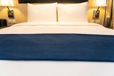 White comfortable pillow and blanket on bed decoration in bedroom interiorの写真素材