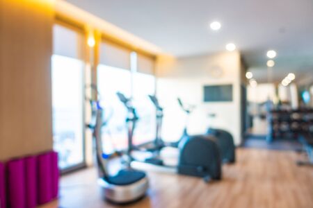 Abstract blur gym room interior with fitness equipment for background