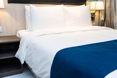 White comfortable pillow and blanket on bed decoration in bedroom interior