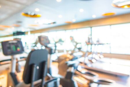 Abstract blur gym room interior with fitness equipment for background
