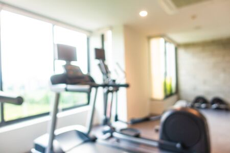 Abstract blur gym room interior with fitness equipment for background