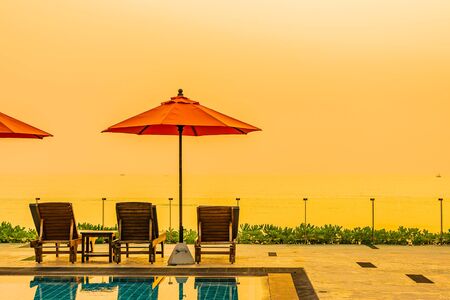 Beautiful sunrise around with umbrella and chair outdoor swimming pool for travel vacationの写真素材