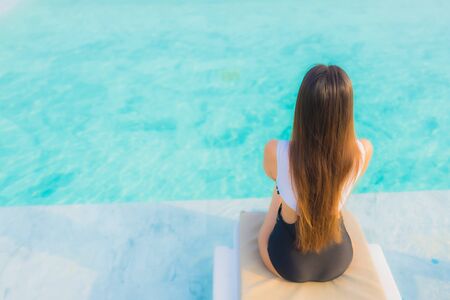 Portrait beautiful young asian woman happy smile relax around outdoor swimming pool in hotel resort for travel vacationの写真素材