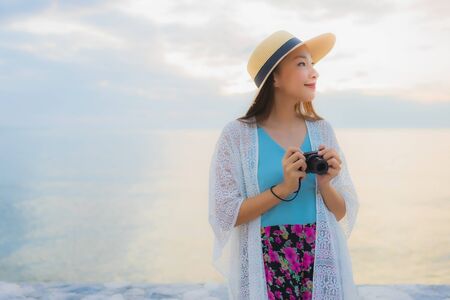 Portrait beautiful young asian women happy smile relax around sea beach ocean at sunrise or sunset timeの写真素材