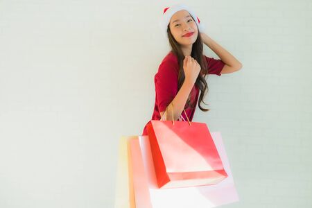 Portrait beautiful young asian women wear christmas santa hat with shopping bag from department storeの写真素材