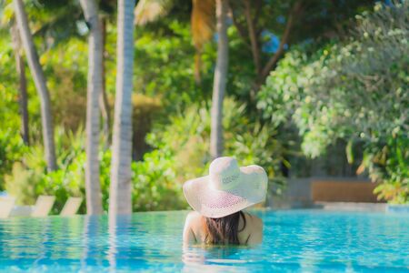 Portrait beautiful young asian woman happy smile relax around outdoor swimming pool in hotel resort...