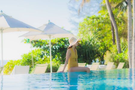 Portrait beautiful young asian woman happy smile relax around outdoor swimming pool in hotel resort for leisure travel vacationの写真素材
