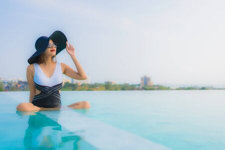 Portrait beautiful young asian woman happy smile relax around outdoor swimming pool in hotel resort for travel vacationの写真素材