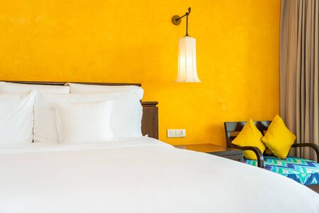 White comfortable pillow on bed decoration interior of bedroom with light lampの写真素材