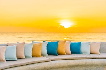 Comfortable pillow on sofa chair around outdoor patio with sea ocean beach view for travel vacation at sunriseの写真素材