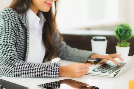 Portrait beautiful young asian woman use credit card with laptop for online shopping itemの写真素材