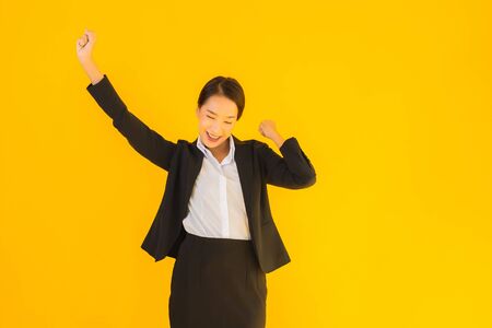 Beautiful portrait young business asian woman happy smile in many action on yellow isolated backgroundの写真素材