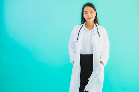 Portrait beautiful young asian doctor asian woman work at clinic or hospital on blue isolated backgroundの写真素材
