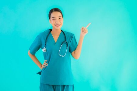 Portrait beautiful young asian doctor woman happy smile for work in hospital and clinic on blue isolated backgroundの写真素材