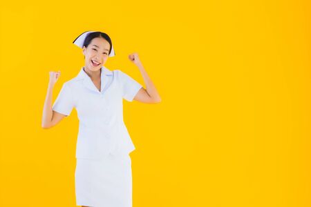 Portrait beautiful young asian thai nurse in many action work for patient in clinic and hospital on yellow isolated backgroundの写真素材