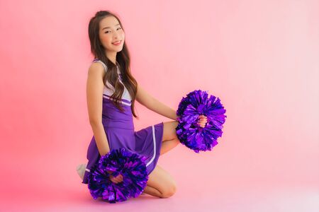 Portrait beautiful young asian woman cheerleader smile happy on isolated pink backgroundの写真素材