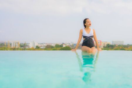 Portrait beautiful young asian woman happy smile relax around outdoor swimming pool in hotel resort for travel vacationの写真素材