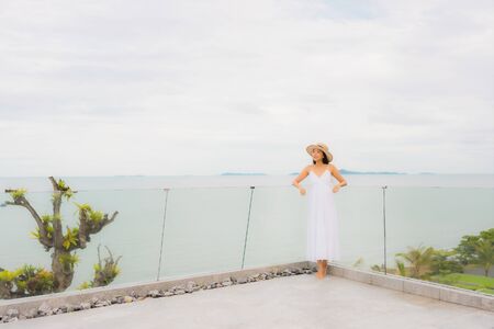 Portriat beautiful young asian woman happy smile around balcony with sea view backgroundの写真素材