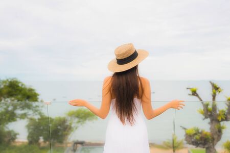 Portriat beautiful young asian woman happy smile around balcony with sea view backgroundの写真素材