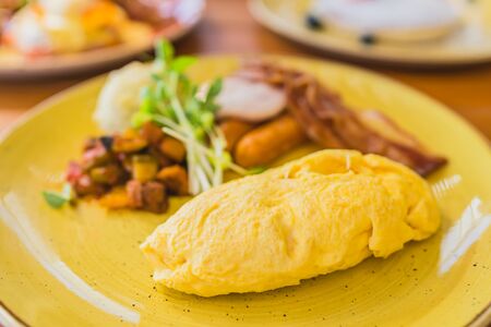 Omelette with sausage bacaon ham with vegetable in plate for breakfastの写真素材