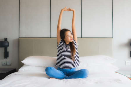 Portrait beautiful young asian woman relax happy smile in bedroom interiorの写真素材