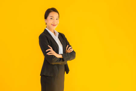 Beautiful portrait young business asian woman happy smile in many action on yellow isolated backgroundの写真素材