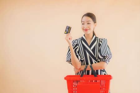 Portrait beautiful young asian woman with shopping basket for grocery in supermarketの写真素材