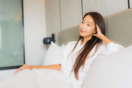 Portrait beautiful young asian woman relax happy smile in bedroom interiorの写真素材