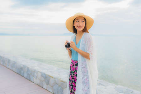 Portrait beautiful young asian women happy smile relax around sea beach ocean at sunrise or sunset timeの写真素材