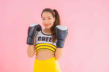 Portrait beautiful young asian woman cheerleader with boxing action on pink isolated backgroundの写真素材