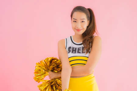 Portrait beautiful young asian woman cheerleader on pink isolated backgroundの写真素材