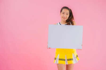 Portrait beautiful young asian woman show white empty billboard for text on pink isolated backgroundの写真素材