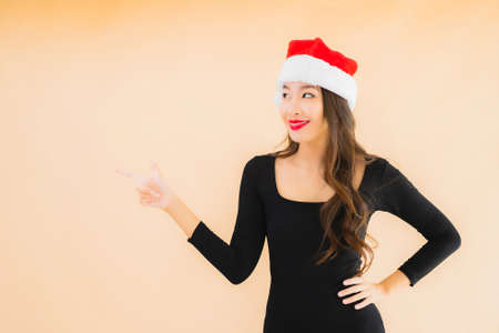 Portrait beautiful young asian woman wear christmas hat on color isolated backgroundの写真素材