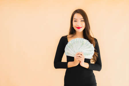 Portrait beautiful young asian woman smile happy with money and cash on color isolated backgroundの写真素材