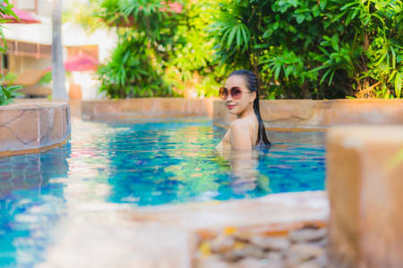 Portrait beautiful young asian woman relax around swimming pool in hotel resort for leisure in vacationの写真素材