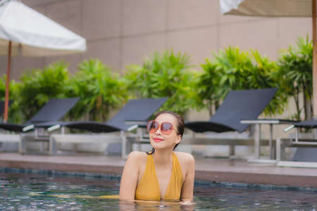 Portrait beautiful young asian woman leisure relax smile around outdoor swimming pool for vacation