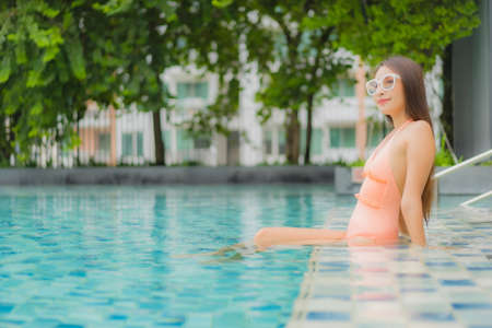 Portrait beautiful young asian woman relax smile leisure around outdoor swimming pool in hotel...